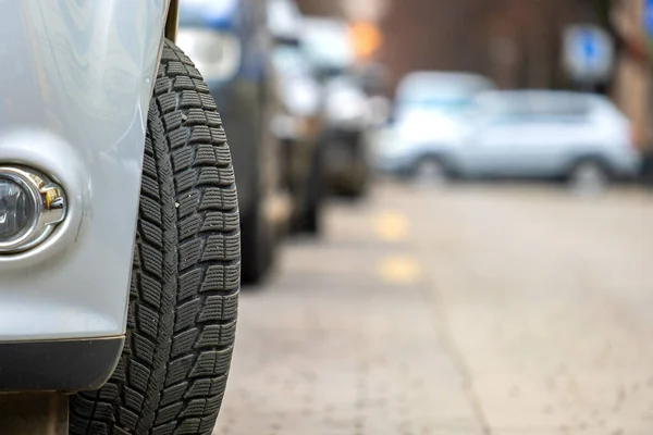 用新的冬季橡胶轮胎把停放在城市路边的汽车挡住 — 图库照片