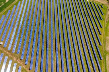Temiz ekolojik elektrik enerjisi üretmek için birçok sıra güneş fotovoltaik paneli bulunan sürdürülebilir büyük elektrik santralinin havadan görünüşü. Sıfır emisyon kavramı ile yenilenebilir elektrik.