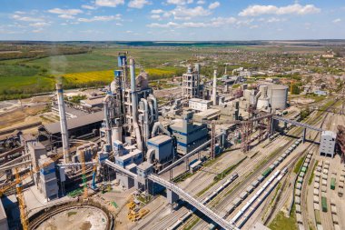 Yüksek beton yapısı olan çimento fabrikasının havadan görünüşü ve endüstriyel üretim alanında kule vinci. Üretim ve küresel sanayi kavramı.