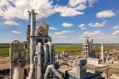 Yüksek beton yapısı olan çimento fabrikasının havadan görünüşü ve endüstriyel üretim alanında kule vinci. Üretim ve küresel sanayi kavramı.