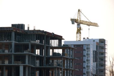 Vinçler ve inşaat halindeki yüksek konutlu binalar. Gayrimenkul geliştirme.