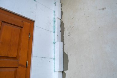 Termal koruma için ev cephesi duvarına köpük yalıtım çarşafları kurulumu.