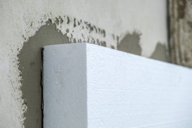 Termal koruma için ev cephesi duvarına köpük yalıtım çarşafları kurulumu.