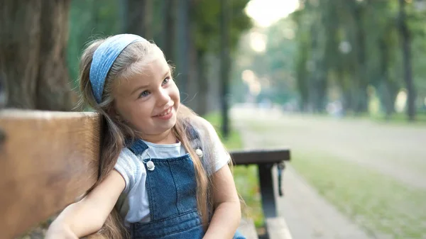 Malá Šťastná Holčička Sedí Lavičce Šťastně Usmívá Letním Parku — Stock fotografie