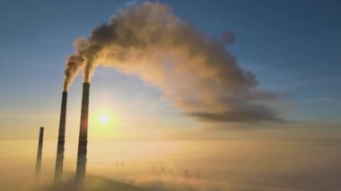 Kara dumanlı yüksek borular güneş doğarken atmosferi kirletiyor..