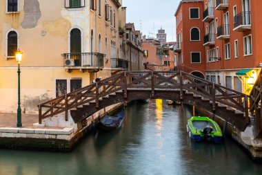 İtalya, Venedik 'te aydınlık eski binaların, yüzen teknelerin ve kanal suyundaki ışık yansımalarının gece görüşü.