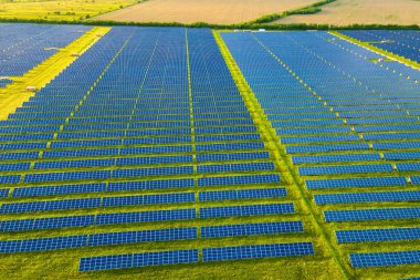 Temiz ekolojik elektrik enerjisi üretmek için birçok sıra güneş fotovoltaik paneli bulunan sürdürülebilir büyük elektrik santralinin havadan görünüşü. Sıfır emisyon kavramı ile yenilenebilir elektrik.