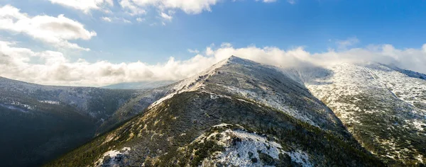 环抱着青翠的云杉林和高高的雪峰的雄伟群山的空中景观 — 图库照片