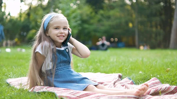 Garotinha Positiva Conversando Seu Telefone Celular Parque Verão Jovem Criança — Fotografia de Stock