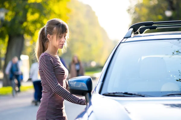 若い幸せな女性ドライバーは夏に街の通りで彼女の車の近くに立っている 目的地や交通の概念 — ストック写真