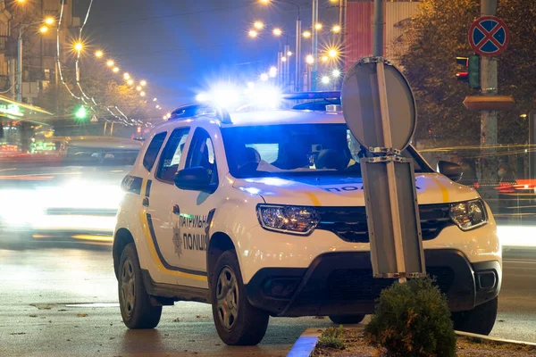 夜の交通と街の路上に駐車警察のパトロール車の明るい青色のライトを点滅 — ストック写真