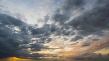 Günbatımında sarı gökyüzünde hızlı hareket eden akşam bulutlarının hızlandırılmış görüntüleri.