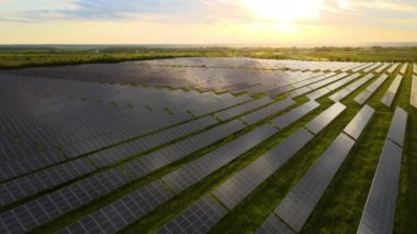 Sabahları temiz ekolojik elektrik enerjisi üretmek için sıra sıra güneş fotovoltaik panelleri olan sürdürülebilir büyük elektrik santralinin havadan görünüşü. Sıfır emisyon kavramı ile yenilenebilir elektrik