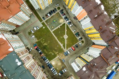Yüksek apartmanlar arasındaki otoparkta park halindeki arabaların hava görüntüsü..