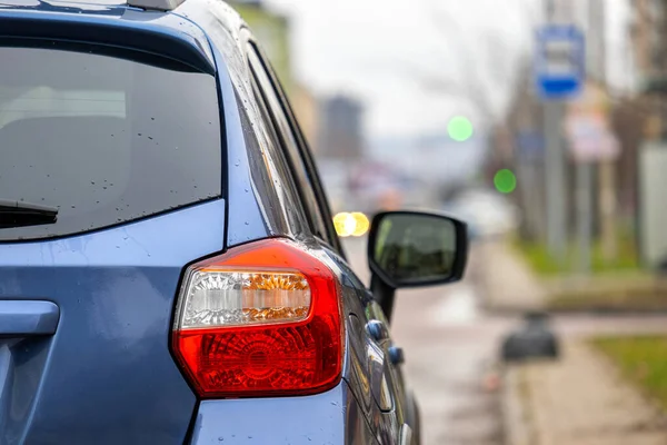 Şehrin sokaklarında park edilmiş yeni temiz bir arabanın arka farının yakın çekimi..