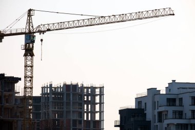 Vinçler ve inşaat halindeki yüksek konutlu binalar. Gayrimenkul geliştirme.