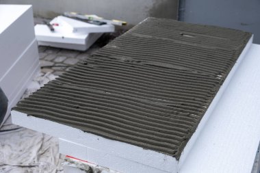 Termal koruma için ev cephesi duvarına köpük yalıtım çarşafları kurulumu.