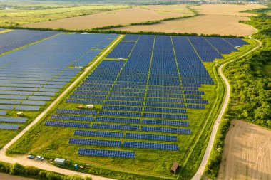 Temiz ekolojik elektrik enerjisi üretmek için birçok sıra güneş fotovoltaik paneli bulunan sürdürülebilir büyük elektrik santralinin havadan görünüşü. Sıfır emisyon kavramı ile yenilenebilir elektrik.
