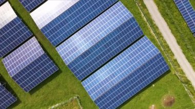 Temiz ekolojik elektrik enerjisi üretmek için sıra sıra güneş fotovoltaik panelleri olan sürdürülebilir büyük elektrik santralinin havadan görünüşü. Sıfır emisyon kavramı ile yenilenebilir elektrik.