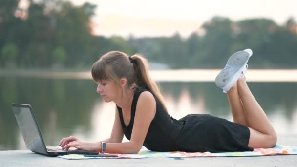 Młoda Kobieta Pracująca Laptopem Podczas Rozmowy Przez Telefon Komórkowy Leżąca — Wideo stockowe