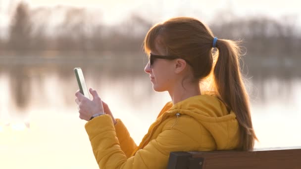 Jovem Mulher Bonita Sentada Banco Parque Falando Seu Smartphone Livre — Vídeo de Stock
