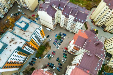 Yüksek apartmanlar arasındaki otoparkta park halindeki arabaların hava görüntüsü..