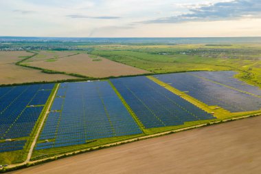 Temiz ekolojik elektrik enerjisi üretmek için birçok sıra güneş fotovoltaik paneli bulunan sürdürülebilir büyük elektrik santralinin havadan görünüşü. Sıfır emisyon kavramı ile yenilenebilir elektrik.