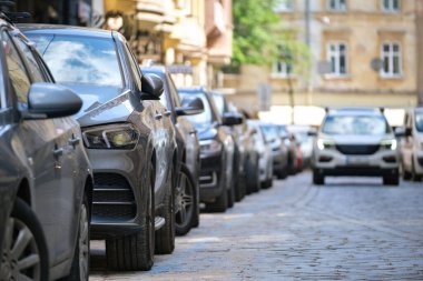 Sokak kenarında park halindeki arabalarla şehir trafiği.