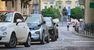 Sokak kenarında park halindeki arabalarla şehir trafiği.