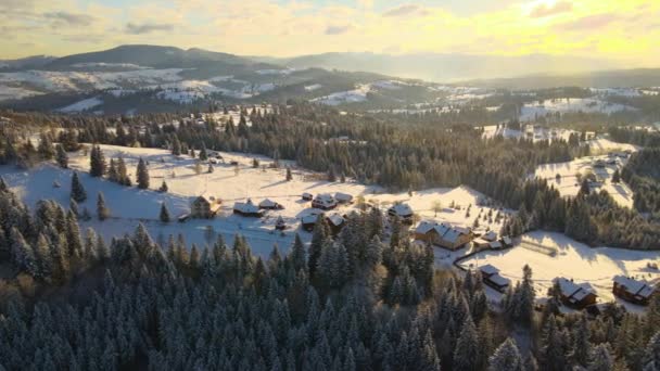 Flygvinterlandskap Med Små Byhus Mellan Snötäckt Skog Kalla Berg Kvällen — Stockvideo