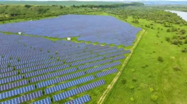 Temiz ekolojik elektrik enerjisi üretmek için birçok sıra güneş fotovoltaik paneli bulunan sürdürülebilir büyük elektrik santralinin havadan görünüşü. Sıfır emisyon kavramı ile yenilenebilir elektrik.
