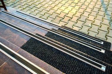 Verandadaki merdivenleri kaplayan seramik karoların üzerinde lastik kaygan çizgiler var..