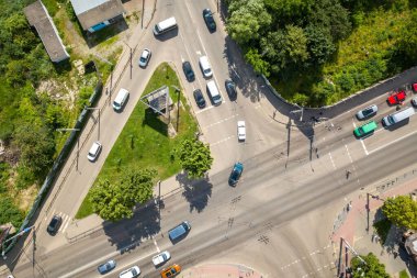 Yoğun cadde kesişiminin hareket halindeki araçlarla yukarıdan aşağı hava görüntüsü.