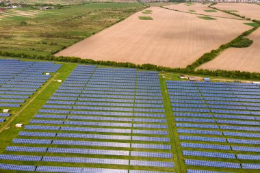 Temiz ekolojik elektrik enerjisi üretmek için birçok sıra güneş fotovoltaik paneli bulunan sürdürülebilir büyük elektrik santralinin havadan görünüşü. Sıfır emisyon kavramı ile yenilenebilir elektrik.