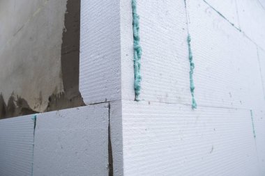 Termal koruma için ev cephesi duvarına köpük yalıtım çarşafları kurulumu.