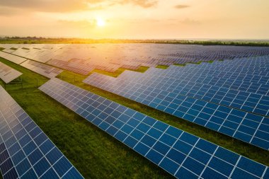 Sabahları temiz ekolojik elektrik enerjisi üretmek için birçok sıra güneş fotovoltaik paneli bulunan sürdürülebilir büyük elektrik santralinin havadan görünüşü. Sıfır emisyon kavramı ile yenilenebilir elektrik.