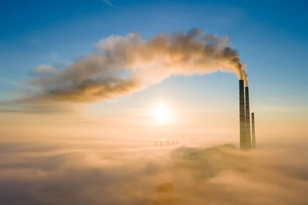 日出时带黑烟向污染大气移动的燃煤电厂高管空中景观 — 图库照片