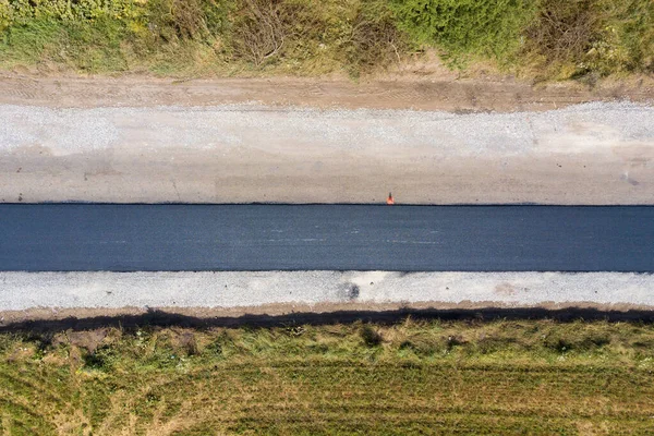 Yeni döşenmiş asfalt şeritli yeni yol yapımının havadan görünüşü.