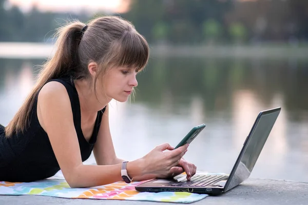 Mujer Joven Que Trabaja Detrás Computadora Portátil Mientras Habla Teléfono — Foto de Stock