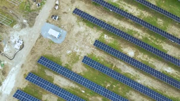 クリーン生態系の電気エネルギーを生成するための金属フレーム上の太陽電池パネルの多くの行を持つ大規模な発電所建設の空中ビュー 再生可能エネルギーの開発 — ストック動画