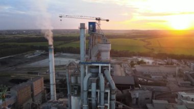 Endüstriyel üretim bölgesinde yüksek beton yapılı çimento fabrikası kulesinin havadan görüntüsü. Üretim ve küresel sanayi kavramı.