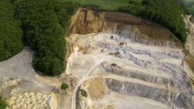 Kazı makineleri ve çöp kamyonlarıyla inşaat kum taşı malzemesi madenciliği.