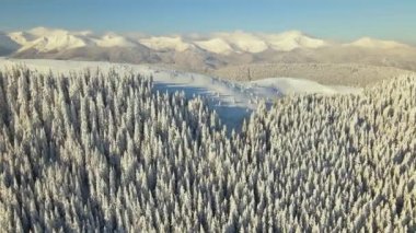 Soğuk, aydınlık bir günde şiddetli kar yağışı sonrası dağ tepeleri ile kaplı, kışın hava manzarası..