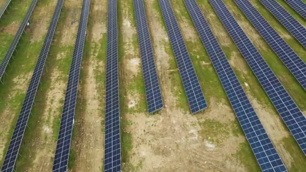 クリーン生態系の電気エネルギーを生成するための金属フレーム上の太陽電池パネルの多くの行を持つ大規模な発電所建設の空中ビュー 再生可能エネルギーの開発 — ストック動画