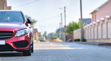 Şehrin caddesine park edilmiş yeni bir arabanın ön görüntüsü..