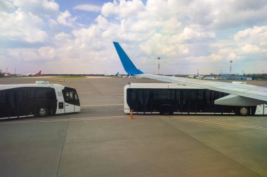 Uçak kanadı ve yolcuları uçaktan terminale taşımak için özel otobüs.