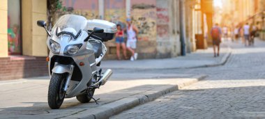 Şehrin caddesinde park etmiş bir motosikletin yakınına..