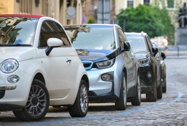 Sokak kenarında park halindeki arabalarla şehir trafiği.