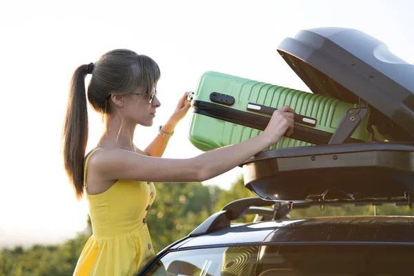 Junge Frau Legt Grünen Koffer Autodachträger Reise Und Urlaubskonzept — Stockfoto