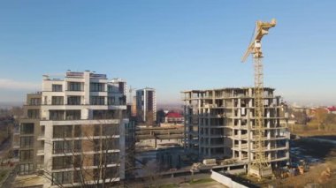 Yüksek kule vincinin ve inşaat halindeki apartmanların havadan görüntüsü. Gayrimenkul geliştirme.